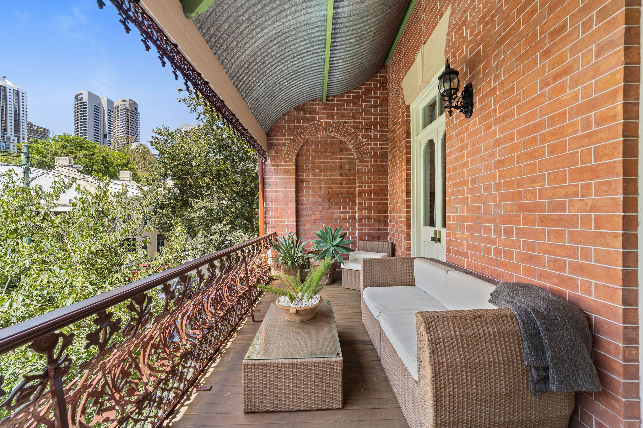 Heritage balcony with iron lacework and city tower views