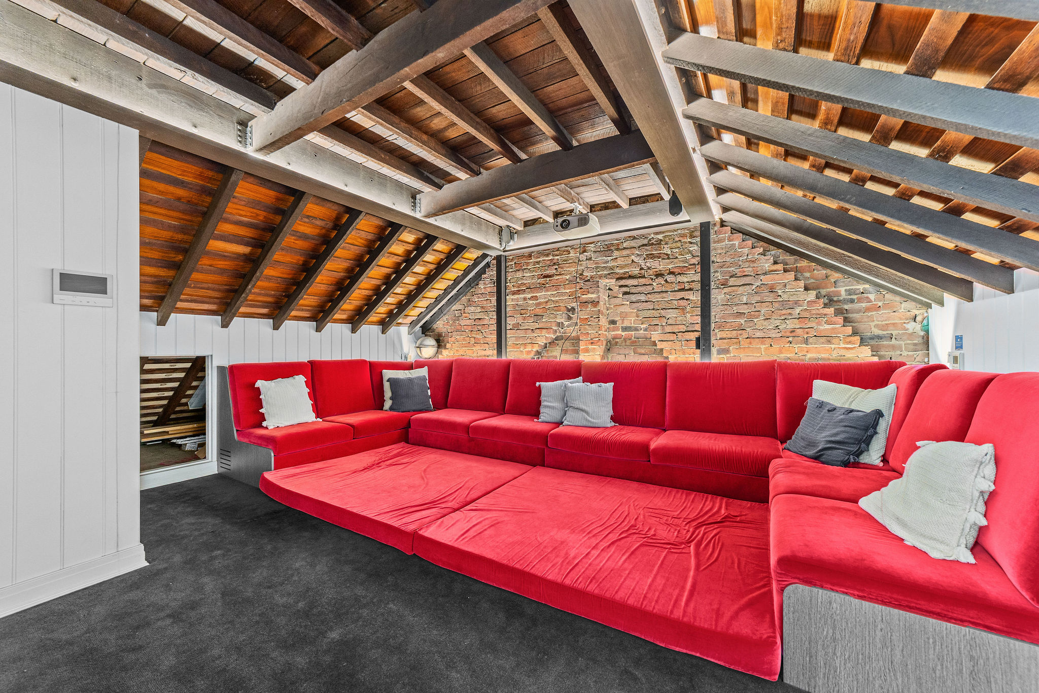 Home cinema with exposed beam ceiling and brick wall
