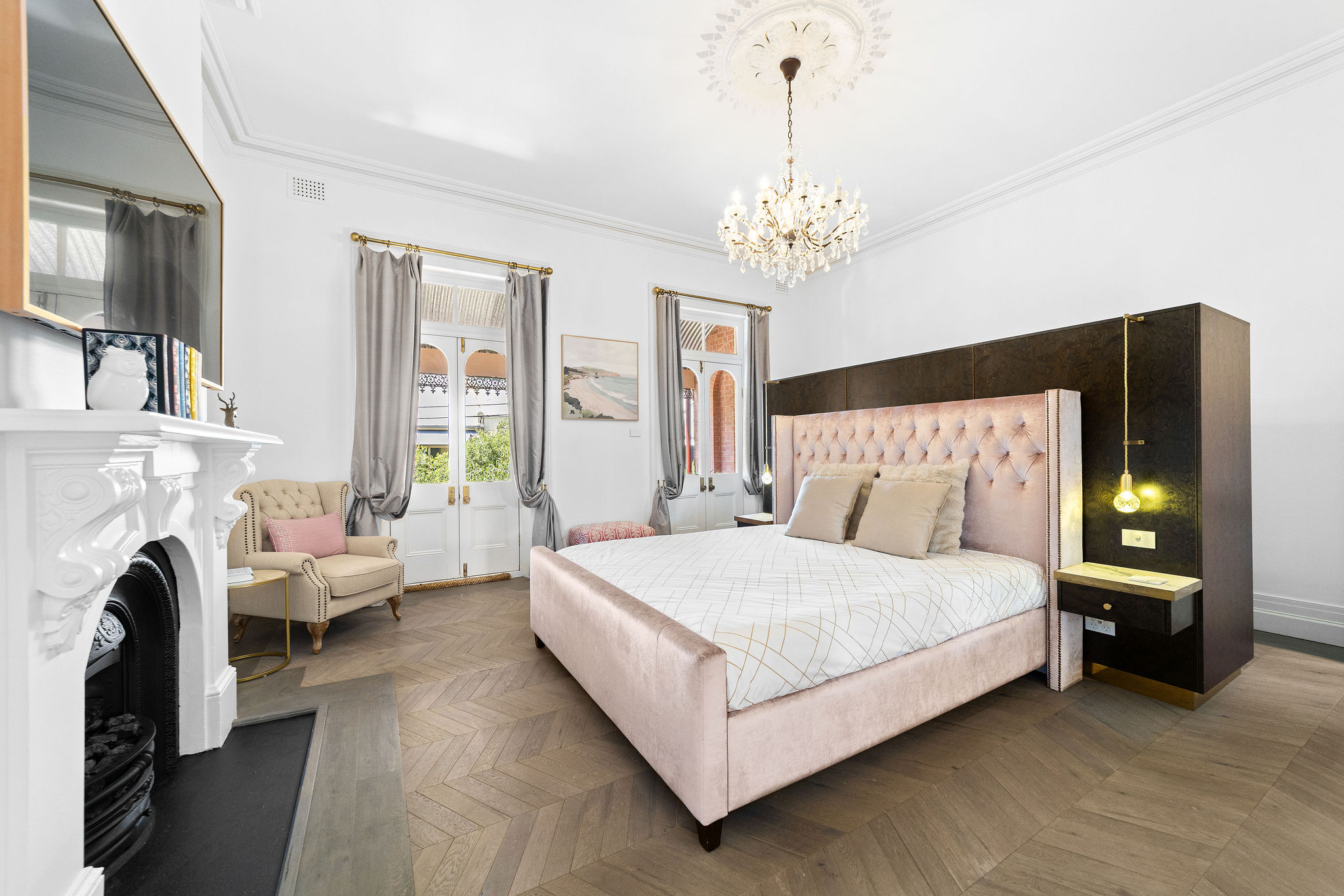 Master bedroom with chandelier, fireplace, and French doors to heritage balcony