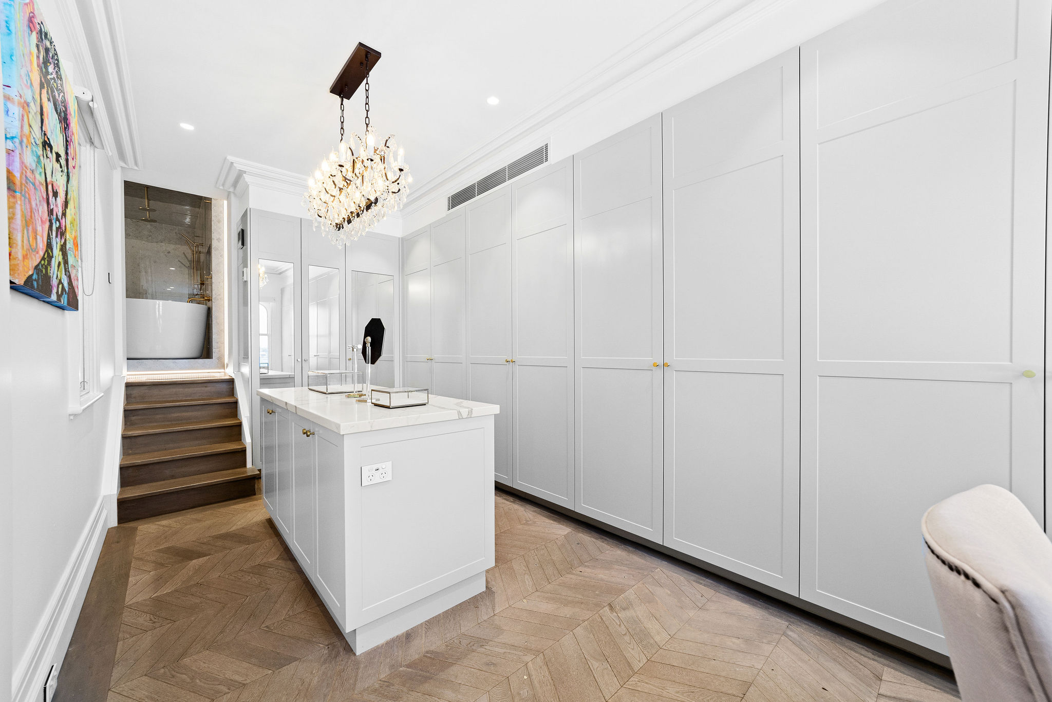 Walk-in robe with marble island bench and floor-to-ceiling cabinetry